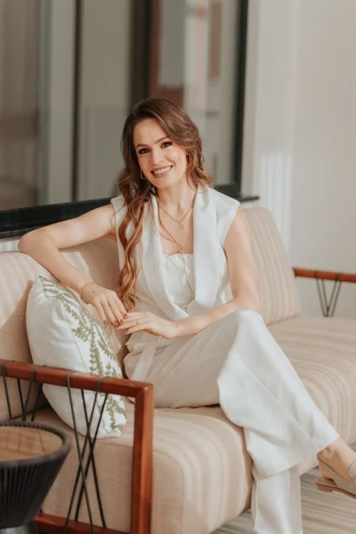 Dra. Vanessa Ludwig sentada em uma poltrona, sorrindo